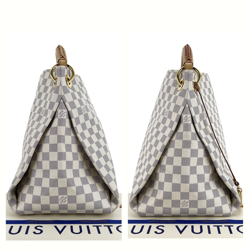 The Artsy MM features a damier azur canvas body, a rolled vachetta handle,  an open top, and interior zip and slip pockets.